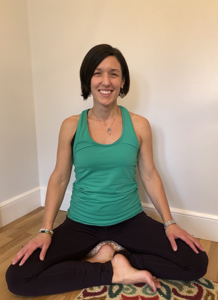 Meghan Kwartler, yoga teacher, seated in a cross-legged pose